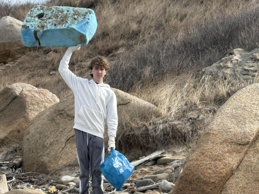 Volunteer holding a large piece of foam debris collected during a beach cleanup on Martha’s Vineyard