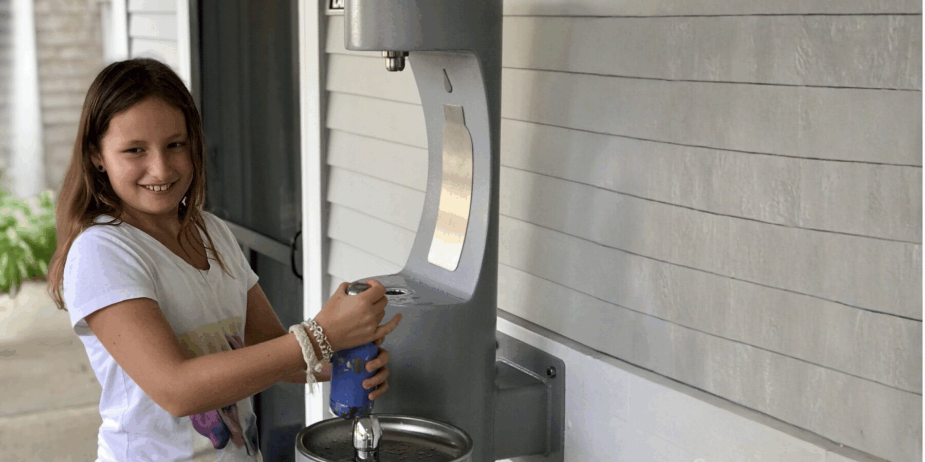 Child refilling a reusable water bottle on Martha’s Vineyard