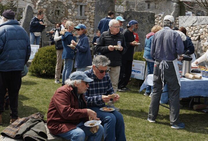Volunteers gathering outdoors for food and conversation after the Vineyard Conservation Society Earth Day Beach Cleanup on Martha’s Vineyard