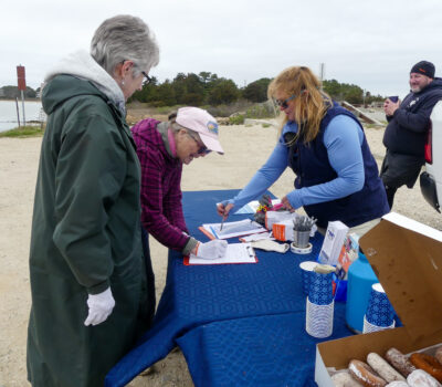 woman helps volunteer fill out trash pick-up survey
