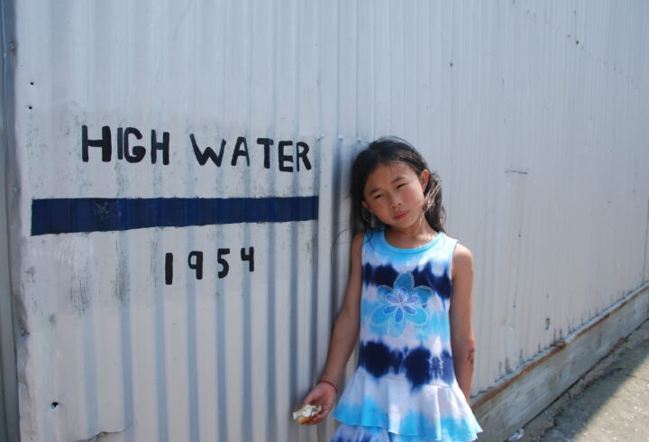 Kid standing by 1954 high water mark